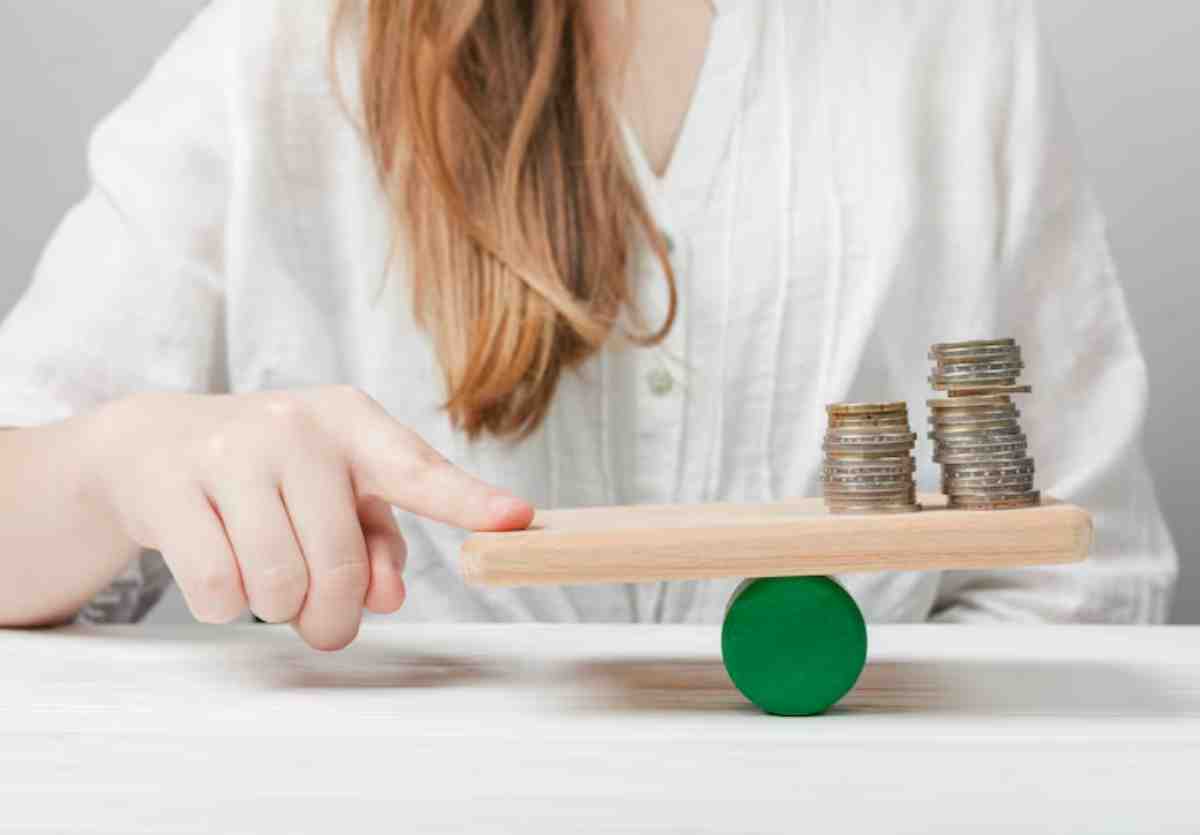 A person balances a wooden plank with stacks of coins on one side, using a green circular base, symbolizing financial decisions.