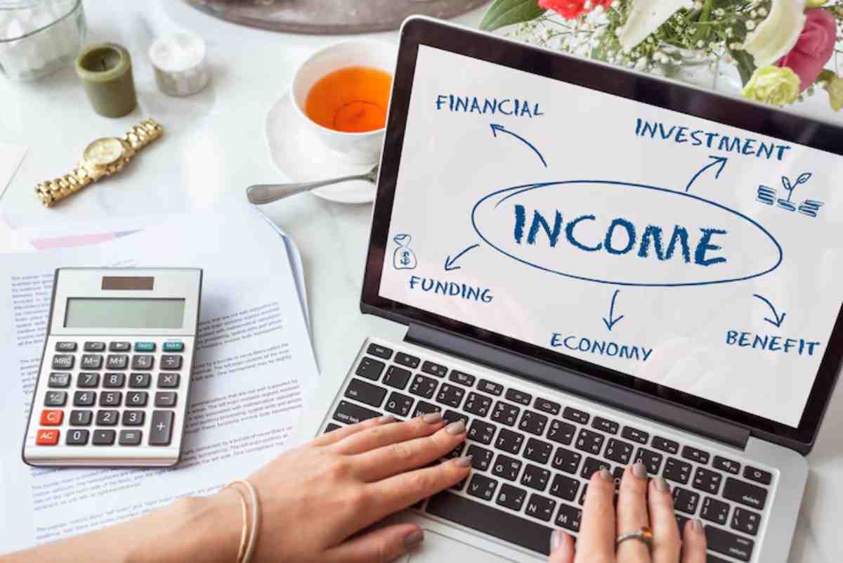 A person types on a laptop displaying a diagram with "INCOME" at the center, surrounded by terms like Financial, investment, and Benefit.