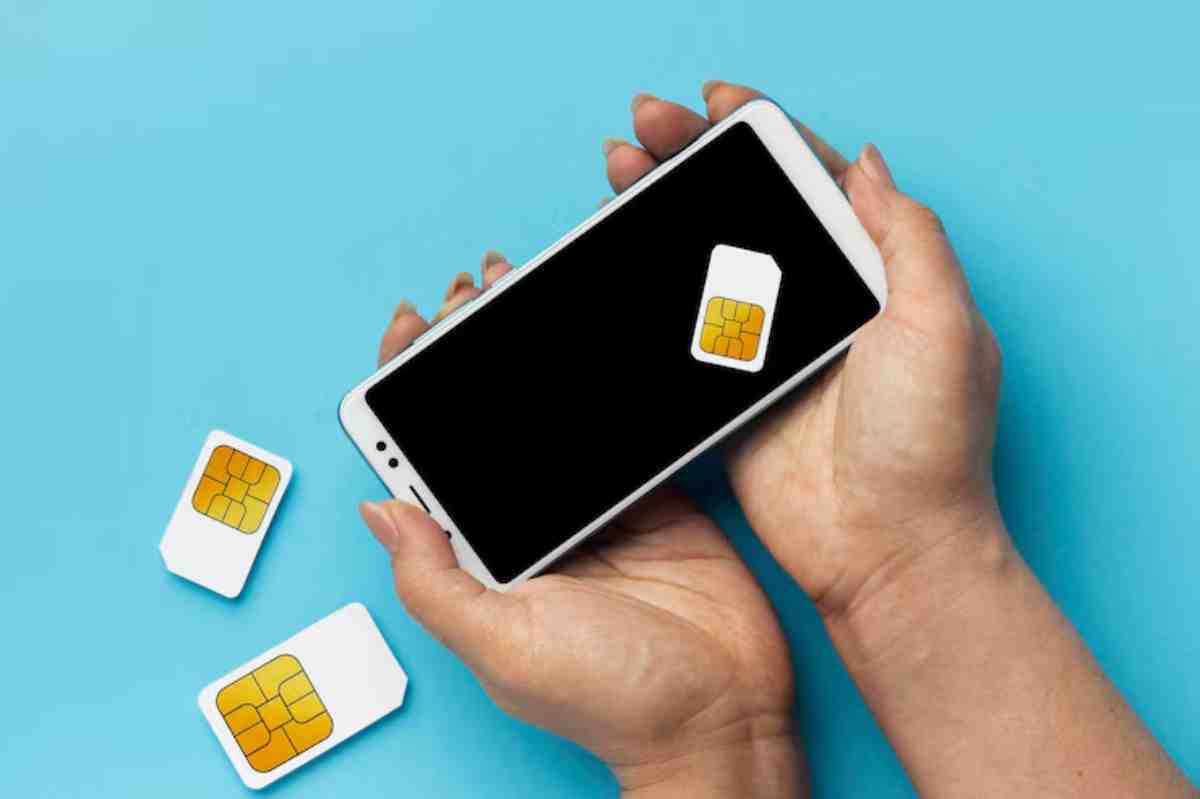 Hands holding a smartphone displaying a SIM card, beside two additional SIM cards on a blue background.