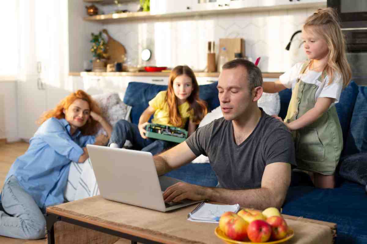 A family in a cozy living room, with one adult working on a laptop while children play nearby, creating a relaxed atmosphere.